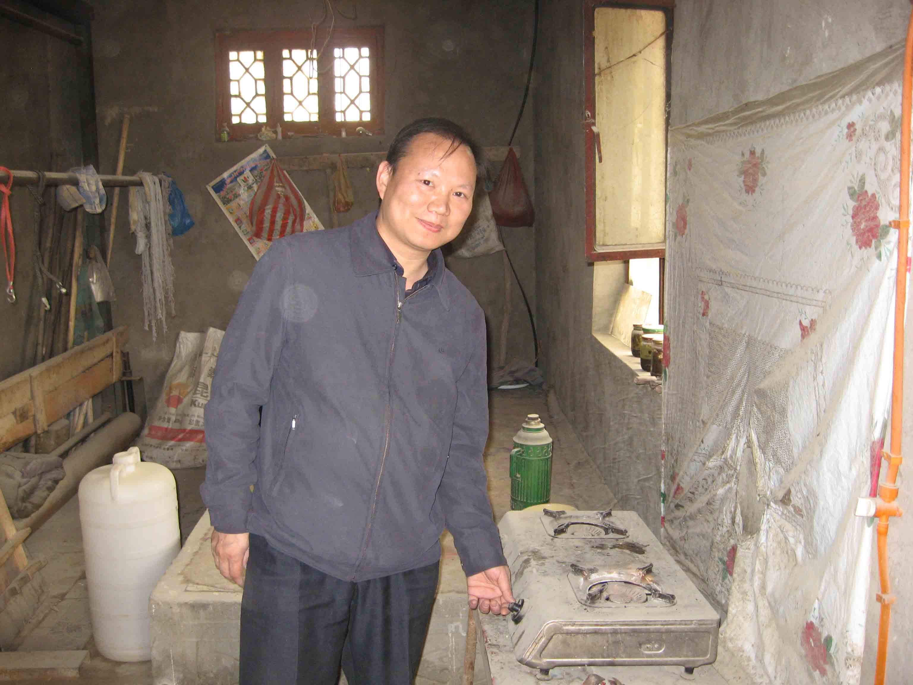 协会工作人员试用当地维吾尔村民家的沼气炉